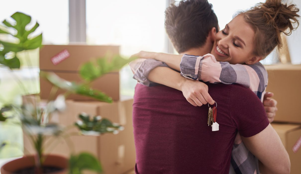 Happy couple with keys of new apartment